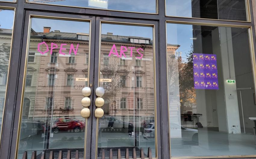 Glastür mit WE ARE Flyern und Open Arts