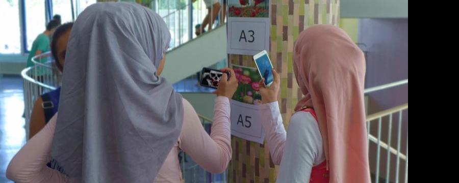 schul-stiegenhaus, zwei jugendliche schauen auf smartphone, markierung an der wand